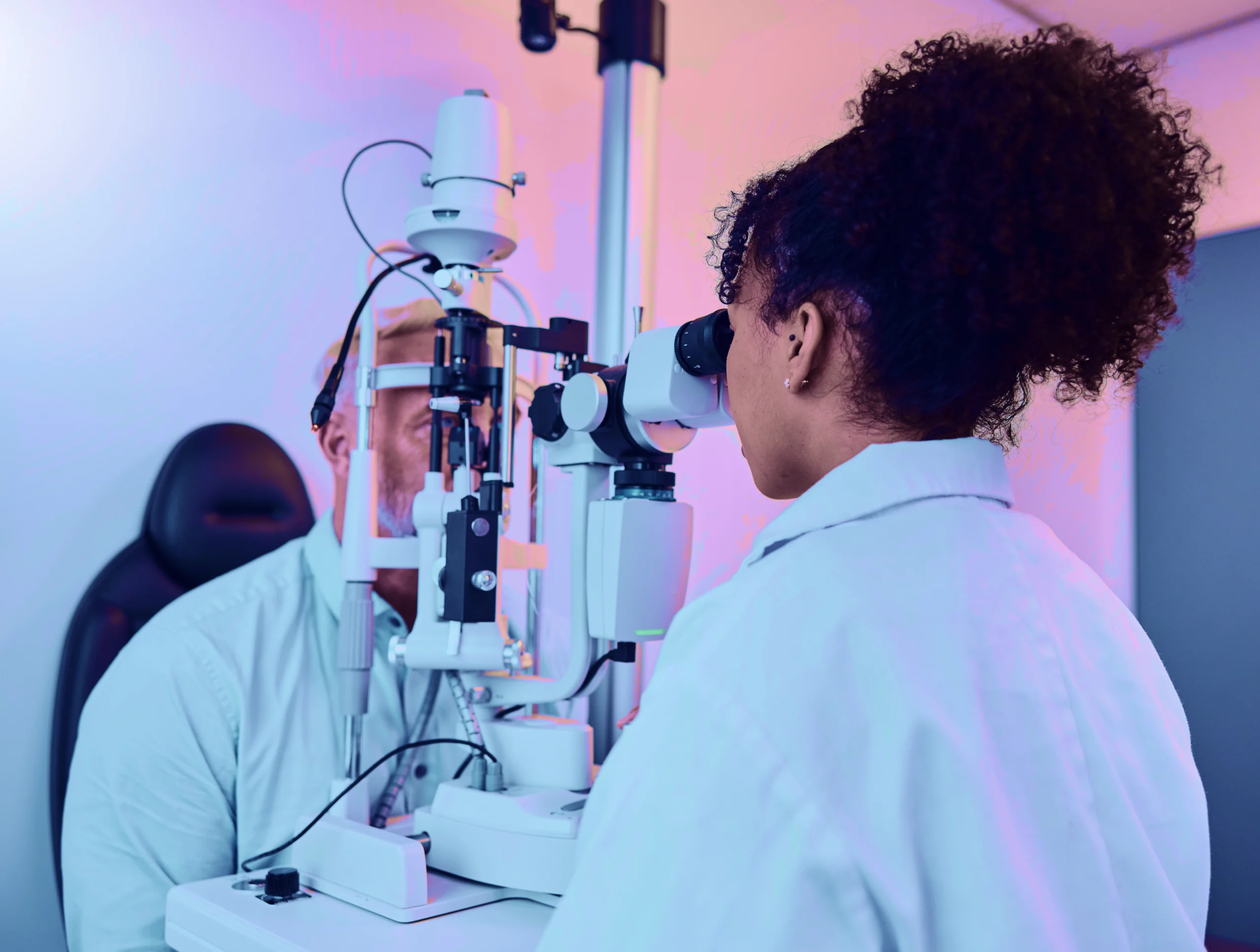 Ophthalmologist examining a patient with a slit lamp in a clinical setting.